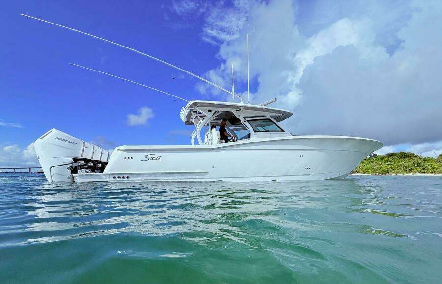 2024 Scout 400 LXF boat on water under clear blue sky.