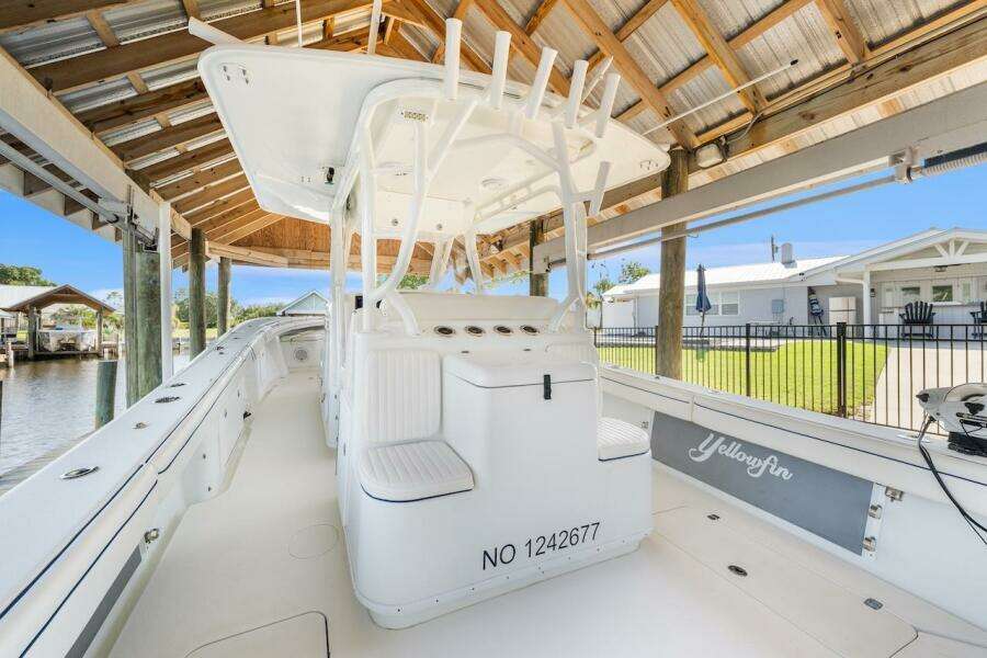 2015 Yellowfin 39 boat docked under a wooden canopy, showcasing sleek design and spacious deck.