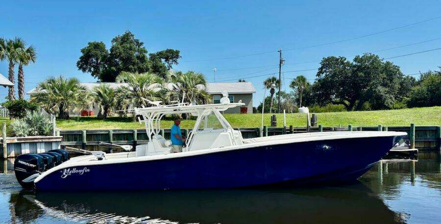 2015 Yellowfin 39 boat docked near lush greenery and palm trees.
