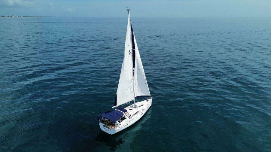 2015 Beneteau Oceanis 45 sailing on calm blue ocean waters.