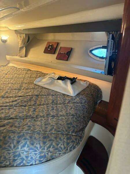 Cozy cabin interior of 2007 Monterey 350 Sport Yacht with patterned bedding and soft lighting.