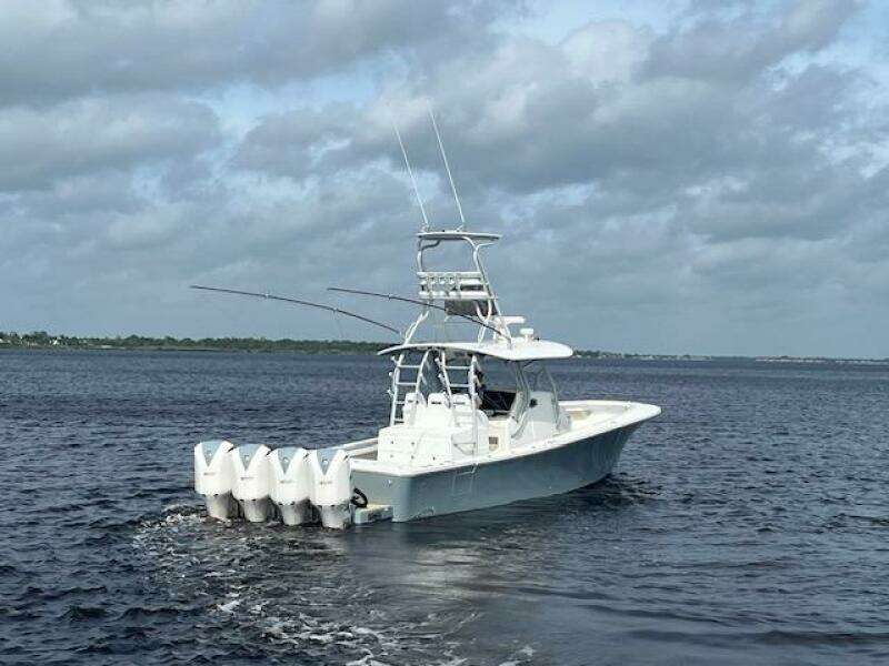 2018 Regulator 41 boat with four engines cruising on open water under cloudy skies.