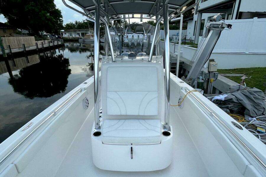 2023 Contender 24 Sport boat interior with seating and console, docked by a canal.