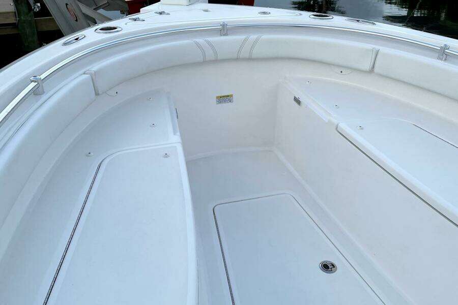 2023 Contender 24 Sport boat interior with white seating and storage compartments.