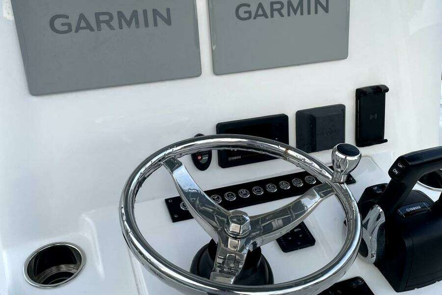 2023 Contender 24 Sport boat dashboard with Garmin displays and steering wheel.