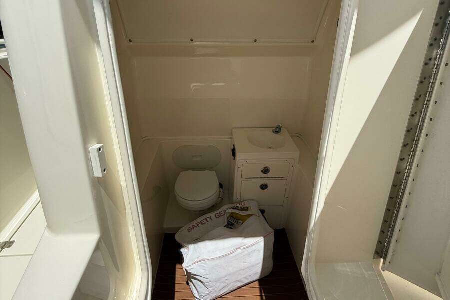 Interior of 2015 Cobia 296 Center Console boat with toilet and sink.