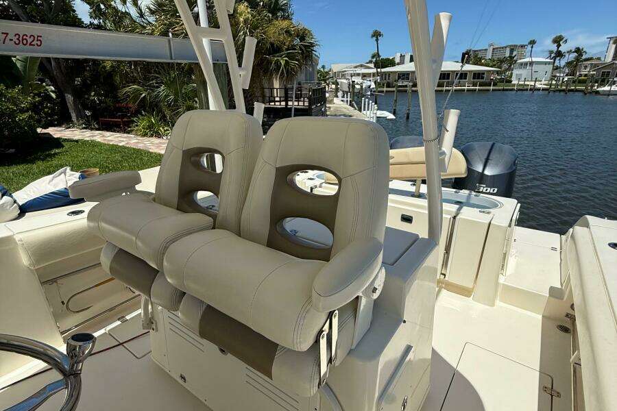 2015 Cobia 296 Center Console boat with beige seating, docked by a waterfront.