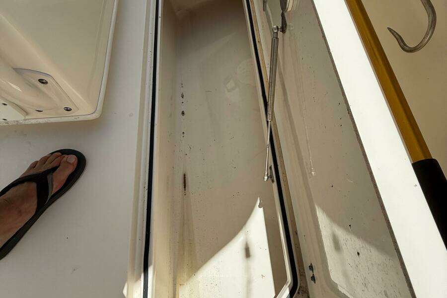 Open storage compartment on 2015 Cobia 296 Center Console boat deck.
