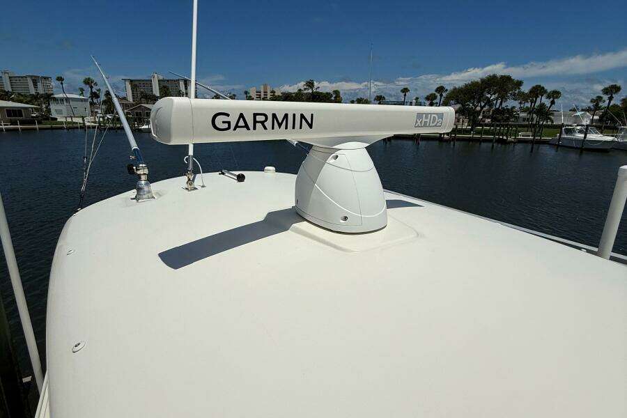2015 Cobia 296 Center Console with Garmin xHD2 radar on deck, docked by waterfront.
