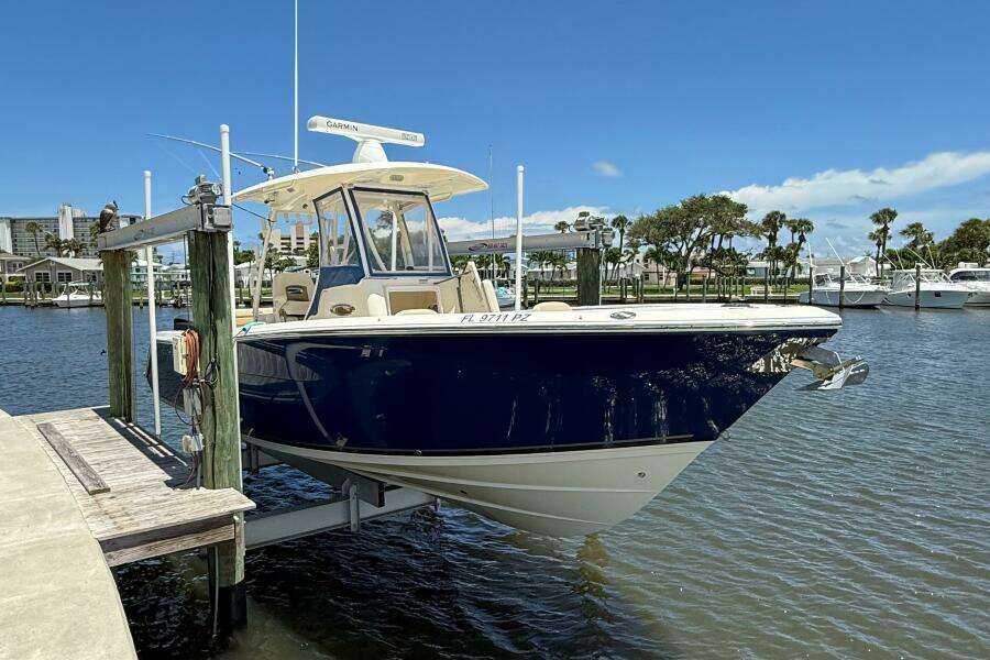 2015 Cobia 296 Center Console boat docked at marina under clear blue sky.