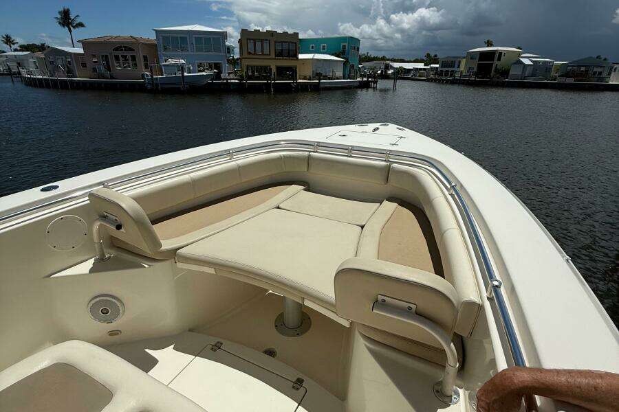 2015 Cobia 296 Center Console boat with spacious seating, docked near waterfront homes.
