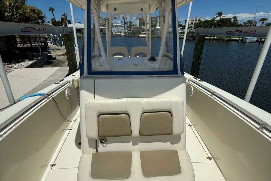 2015 Cobia 296 Center Console boat interior with seating, docked by the waterfront.