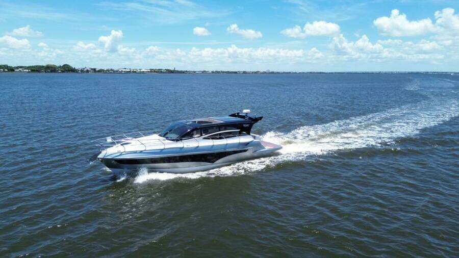 Luxury yacht Real 40 HT cruising on open water under a clear blue sky.