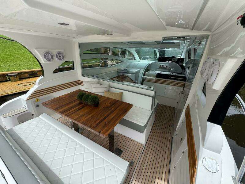 2025 Real 40 HT Luxury yacht interior with elegant seating and wooden table.