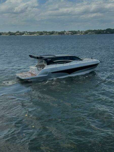 2025 Real 40 HT Luxury yacht cruising on a calm sea under a partly cloudy sky.