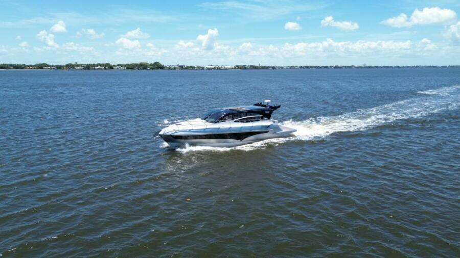 Luxury yacht Real 40 HT cruising on open water under a clear blue sky.