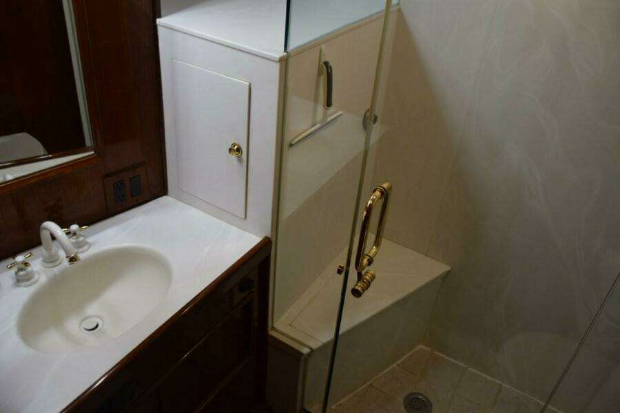 Master vanity top with mirrored medicine cabinet and glass shower enclosure with seat.