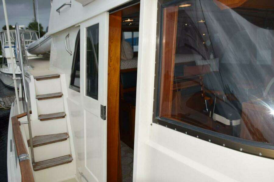 Pilothouse Door and steps up to flybridge. Teak bow rail cap.