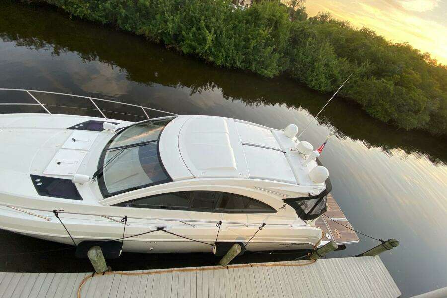 2014 Beneteau Gran Turismo 44 yacht docked by a serene riverbank at sunset.