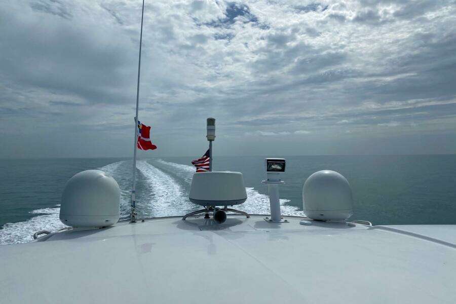 Beneteau Gran Turismo 44 yacht cruising on open sea, 2014 model, with flags flying.