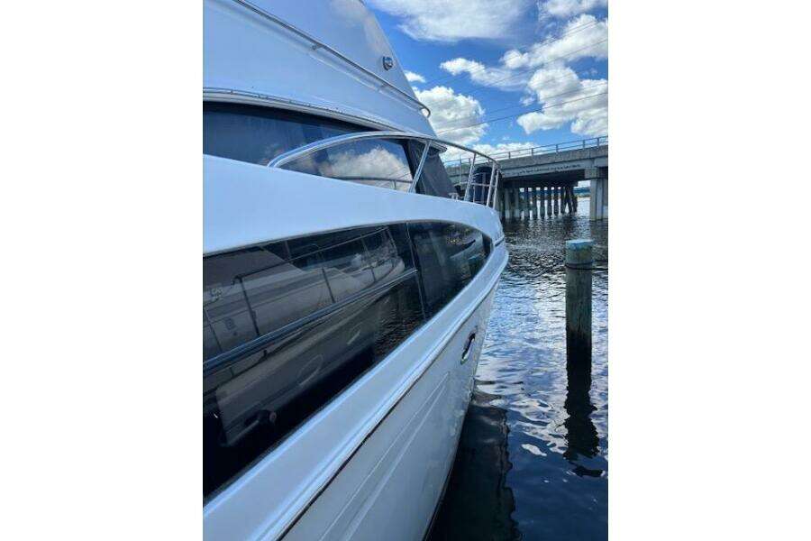 2004 Carver 466 Motor Yacht docked near a bridge under a blue sky. 2004 Carver 466 Motor Yacht docked near a bridge under a blue sky.