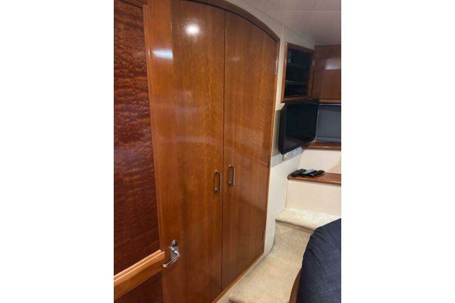 2004 Carver 466 Motor Yacht interior with wooden cabinets and a mounted TV. 2004 Carver 466 Motor Yacht interior with wooden cabinets and a mounted TV.