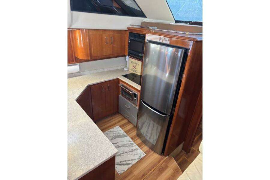 2004 Carver 466 Motor Yacht kitchen with wood cabinetry and stainless steel appliances. 2004 Carver 466 Motor Yacht kitchen with wood cabinetry and stainless steel appliances.