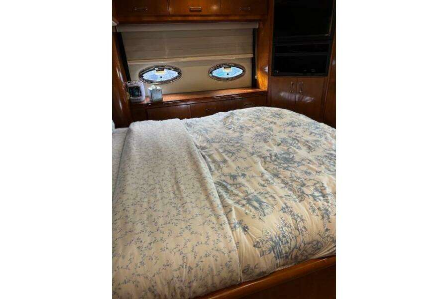 Luxurious bedroom interior of 2004 Carver 466 Motor Yacht with floral bedding and porthole windows. Luxurious bedroom interior of 2004 Carver 466 Motor Yacht with floral bedding and porthole windows.
