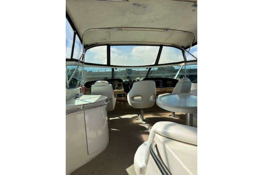 2004 Carver 466 Motor Yacht interior with helm, seating, and panoramic windows. 2004 Carver 466 Motor Yacht interior with helm, seating, and panoramic windows.