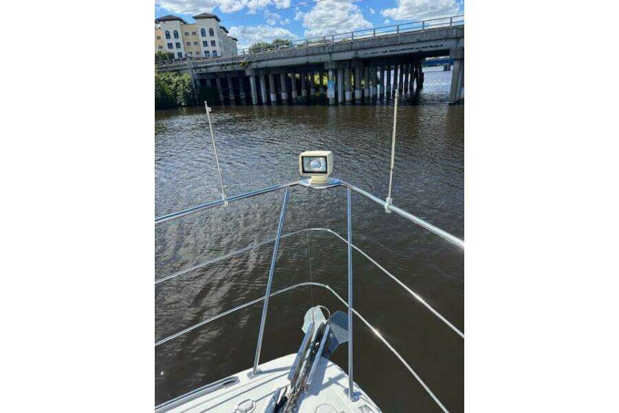 Bow view of 2004 Carver 466 Motor Yacht approaching a bridge on a sunny day. Bow view of 2004 Carver 466 Motor Yacht approaching a bridge on a sunny day.