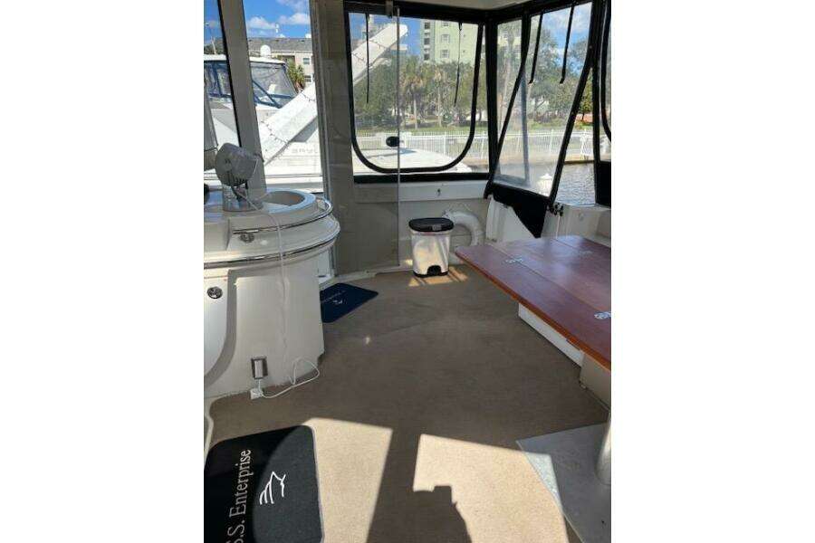 Interior of 2004 Carver 466 Motor Yacht with seating and windows, docked by water. Interior of 2004 Carver 466 Motor Yacht with seating and windows, docked by water.