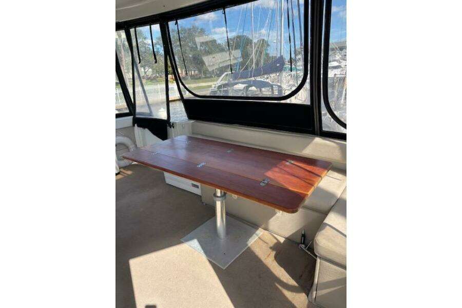 Interior of 2004 Carver 466 Motor Yacht with wooden table and marina view. Interior of 2004 Carver 466 Motor Yacht with wooden table and marina view.