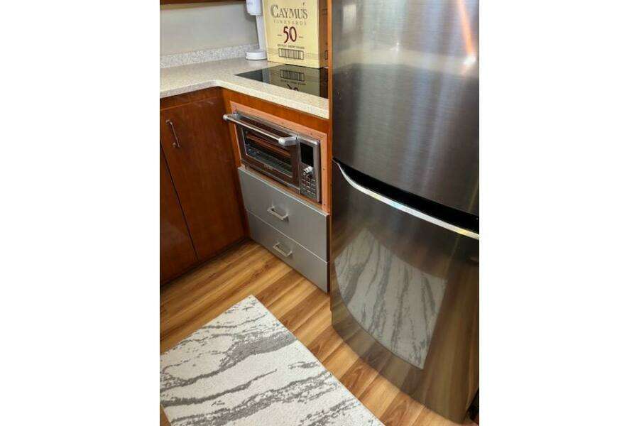 2004 Carver 466 Motor Yacht kitchen with stainless steel fridge, microwave, and wooden cabinetry. 2004 Carver 466 Motor Yacht kitchen with stainless steel fridge, microwave, and wooden cabinetry.