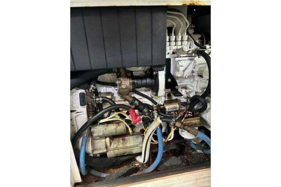 Engine compartment of a 2004 Carver 466 Motor Yacht, showcasing mechanical components and hoses. Engine compartment of a 2004 Carver 466 Motor Yacht, showcasing mechanical components and hoses.