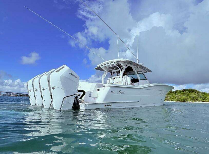 2024 Scout 400 LXF boat with multiple outboard engines on water.