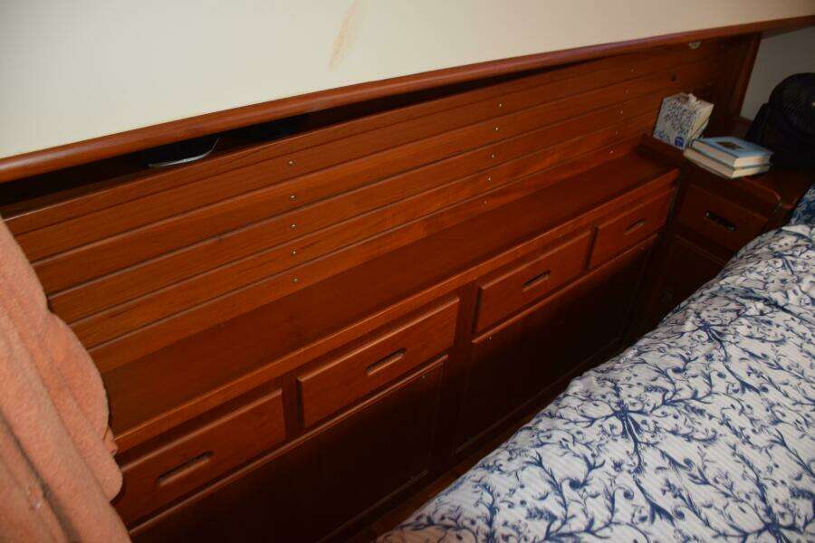 Wooden Cabinetry In A 1997 Grand Banks Classic Boat Interior, Featuring Drawers And A Bed.
