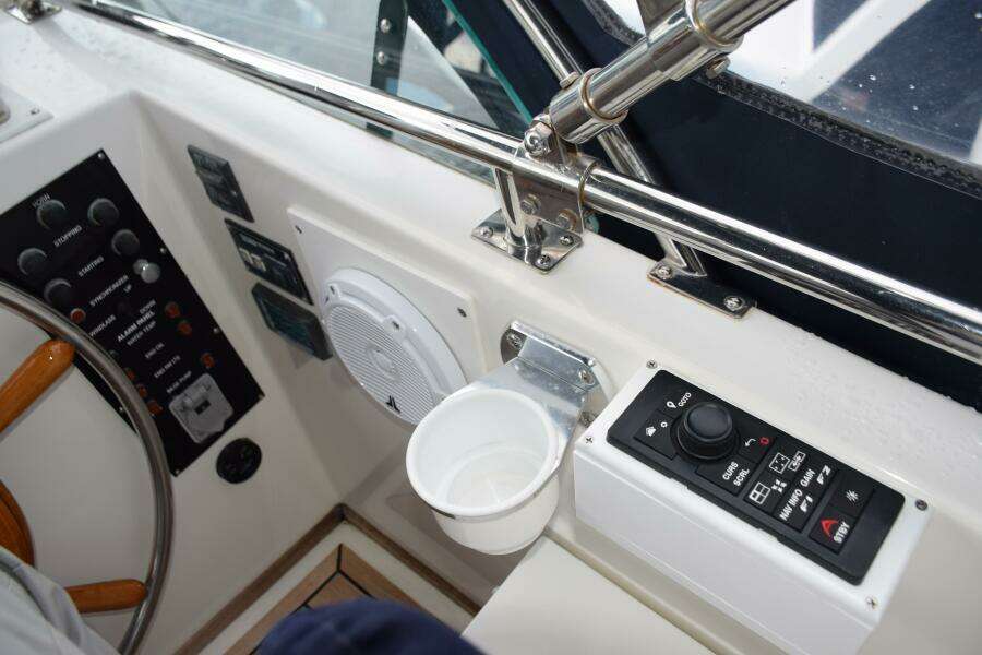 1997 Grand Banks Classic Boat Helm With Controls, Steering Wheel, And Cup Holder.