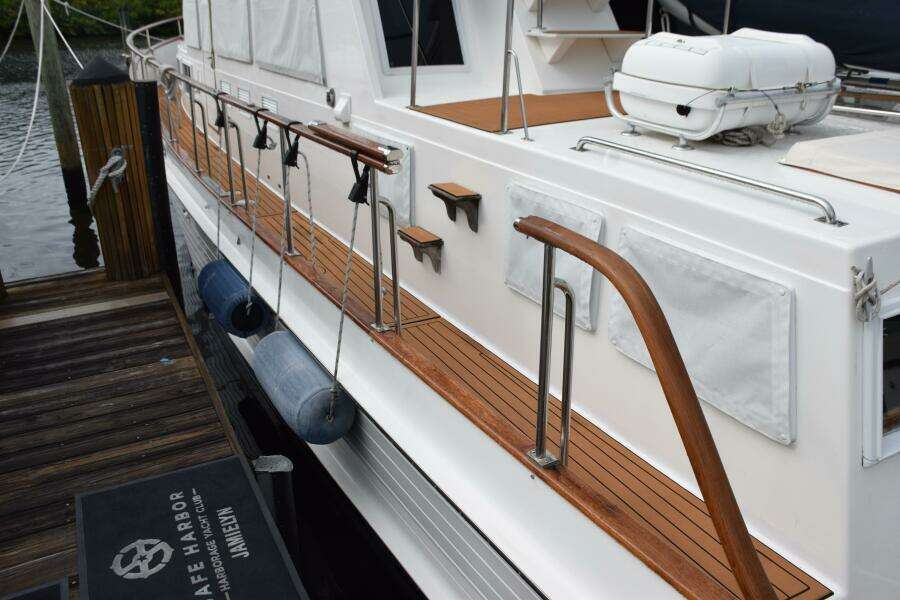 1997 Grand Banks Classic Yacht Docked, Featuring Wooden Deck And Safety Equipment.