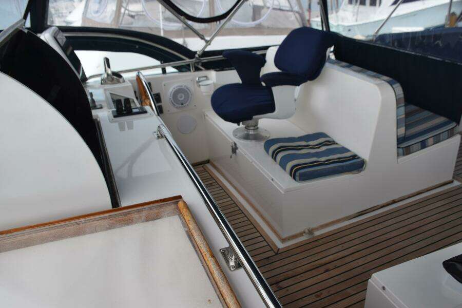 Interior Of 1997 Grand Banks Classic Yacht With Blue Seating And Wooden Deck.