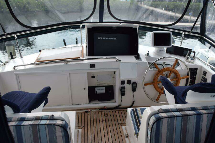1997 Grand Banks Classic Yacht Helm With Wooden Wheel And Navigation Equipment.
