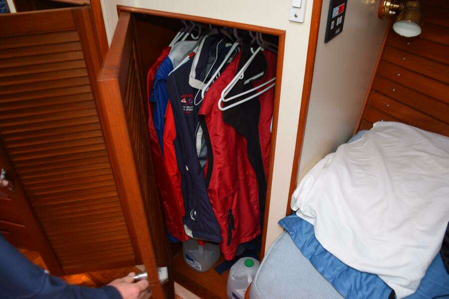 Closet With Jackets On Hangers Inside A 1997 Grand Banks Classic Boat Cabin.