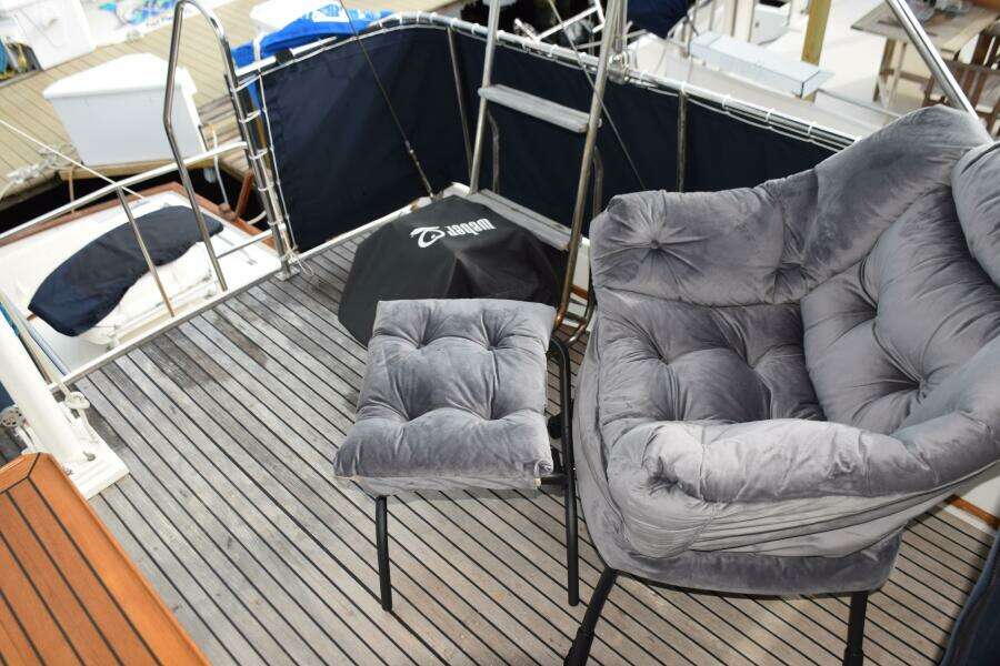 Luxury Seating On 1997 Grand Banks Classic Yacht Deck With Plush Chair And Footrest.