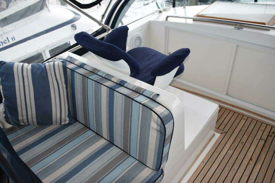 1997 Grand Banks Classic Yacht Interior With Striped Seating And Wooden Flooring.