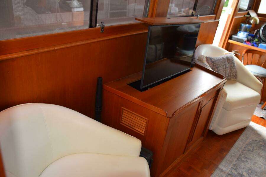 Interior Of 1997 Grand Banks Classic Yacht With TV And White Chairs.