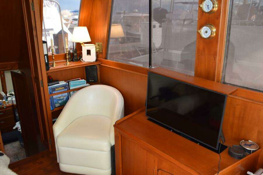 Interior Of 1997 Grand Banks Classic Yacht With Chair, TV, And Nautical Decor.