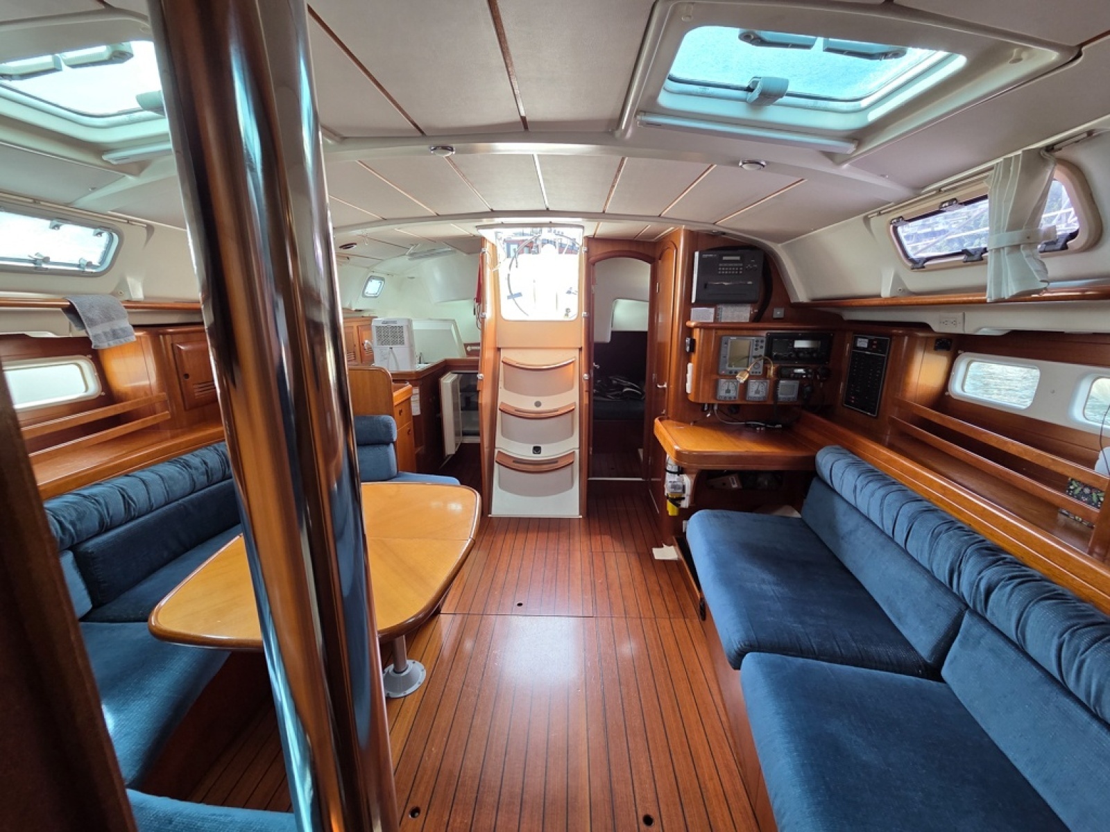 Interior of a 2000 Beneteau Oceanis 411 sailboat with cherry wood finish and blue upholstery