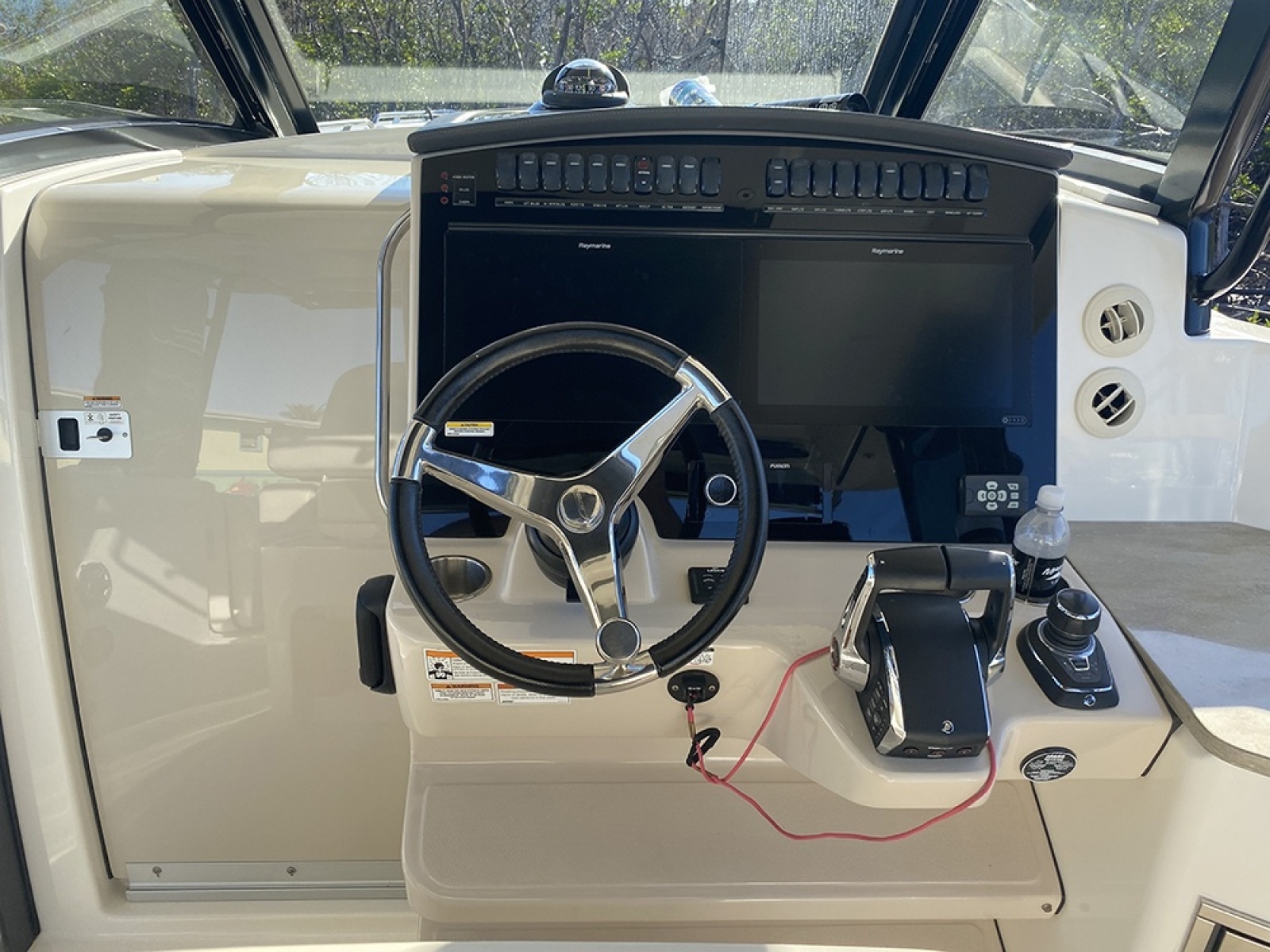 Cockpit of 2023 Boston Whaler 350 Realm with steering wheel and control panel.