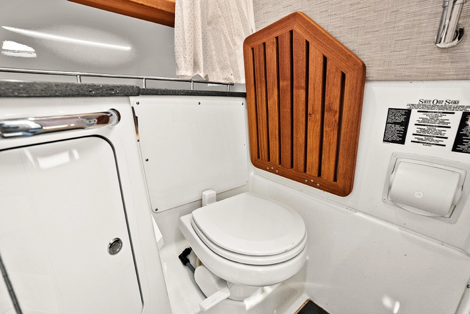 Head with solid teak flip up seat over toilet