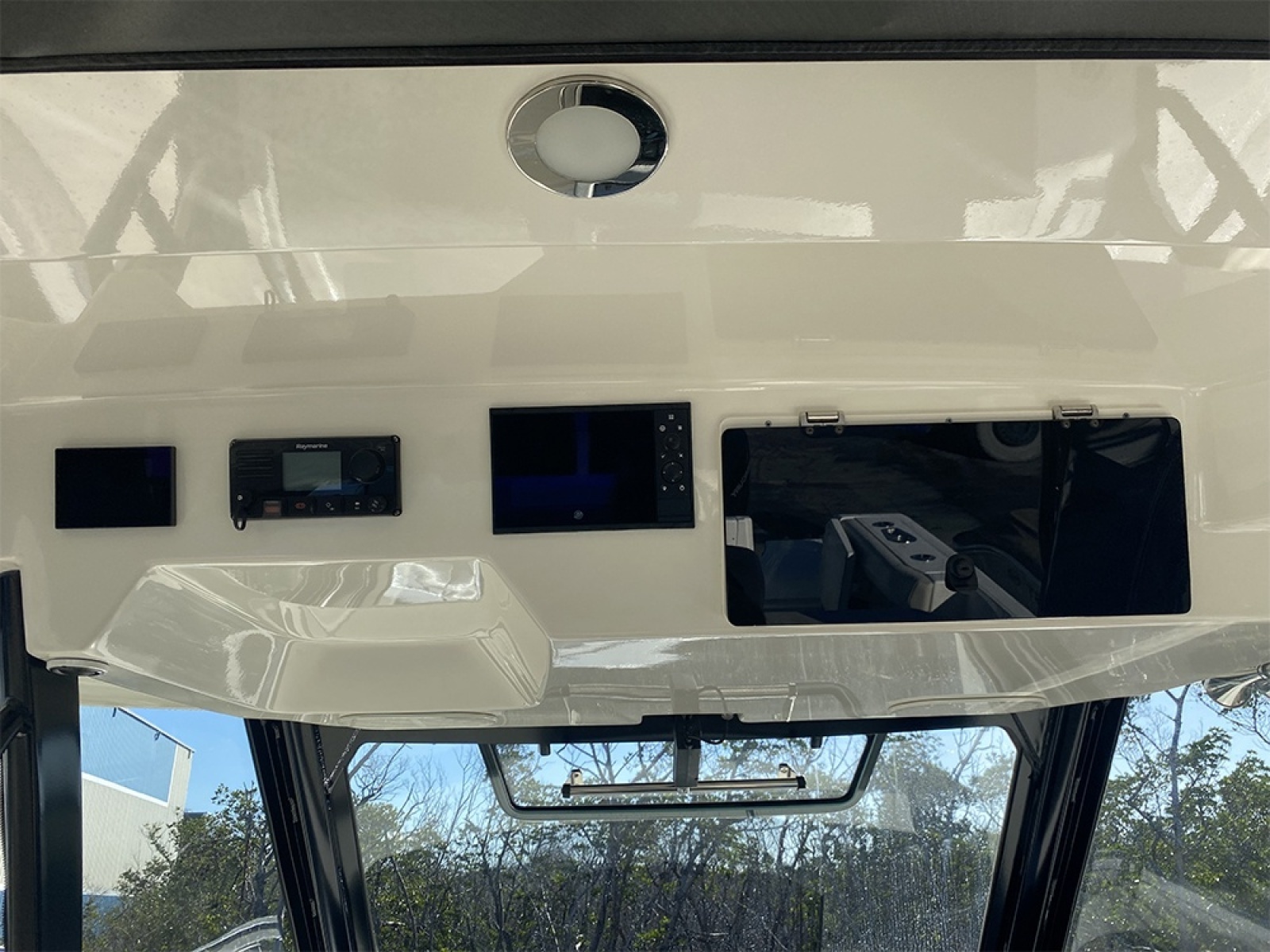 2023 Boston Whaler 350 Realm dashboard with electronic controls and storage compartments.