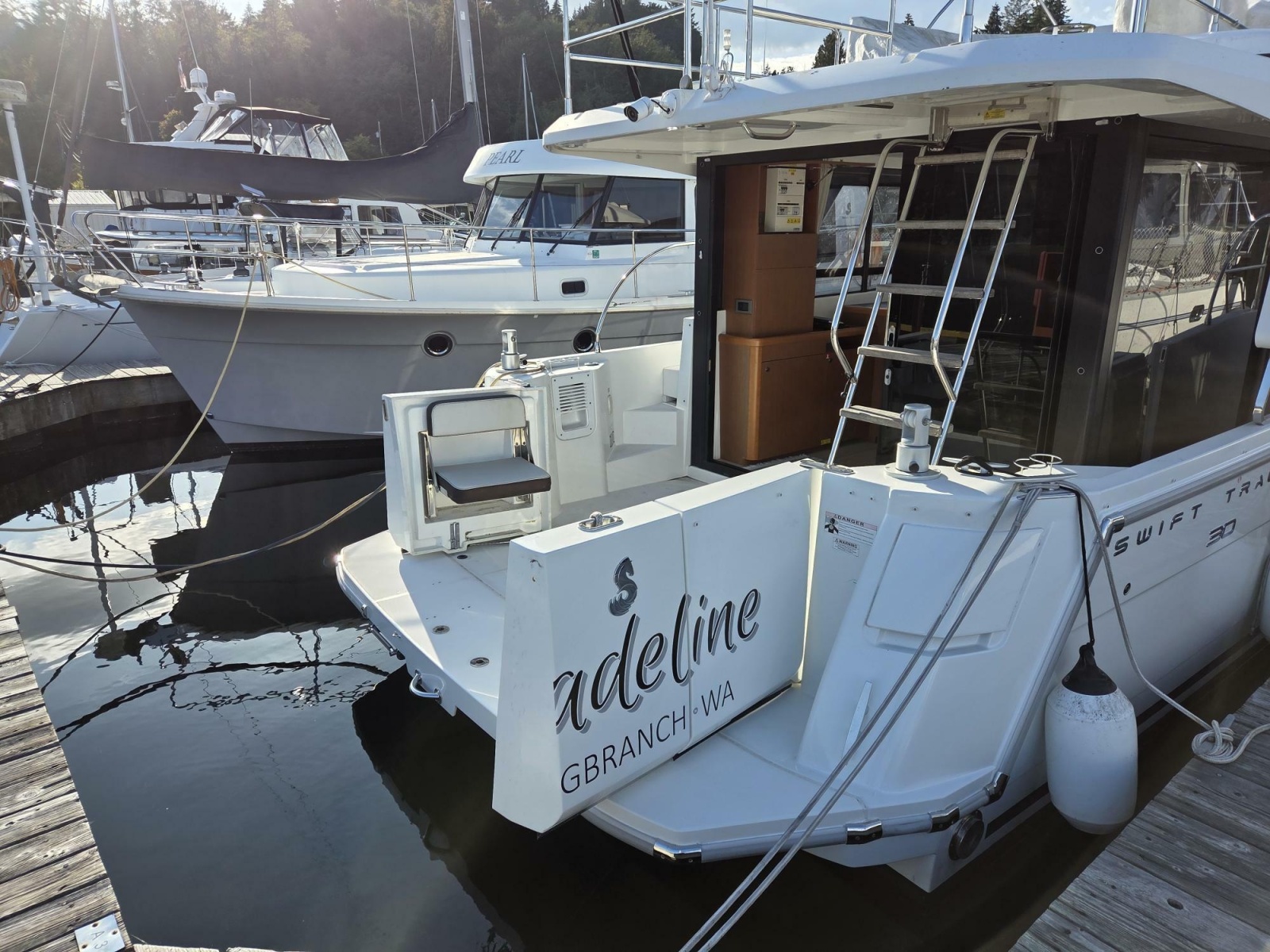 2020 Beneteau Swift Trawler 30 docked at marina, rear view with ladder and seating